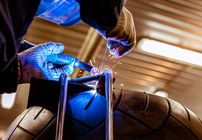 Portrait of worker near metalworking machine, steel factory background.